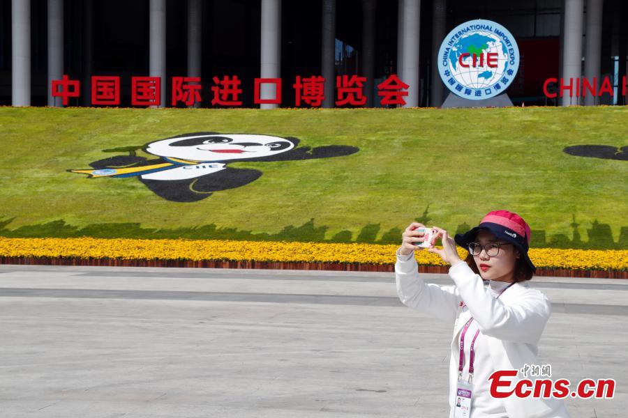 A volunteer takes photos in front of the National Exhibition and Convention Center (Shanghai), the main venue to hold the upcoming first China International Import Expo (CIIE).(Photo: China News Service/Tang Yanjun)