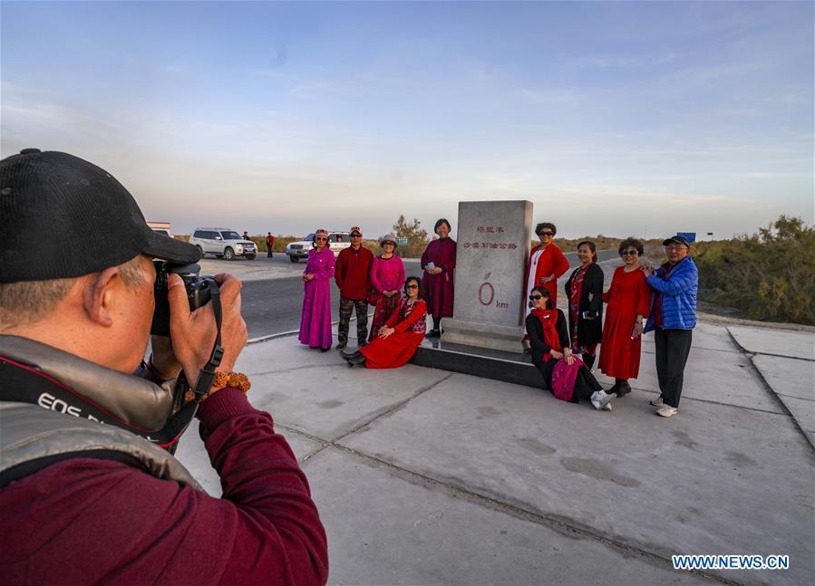 Tourists take a group photo in Tarim, northwest China\'s Xinjiang Uygur Autonomous Region, Oct. 24, 2018. Xinjiang received more than 130 million tourists in the first nine months of 2018, up 38.15 percent year on year. (Xinhua/Zhao Ge)