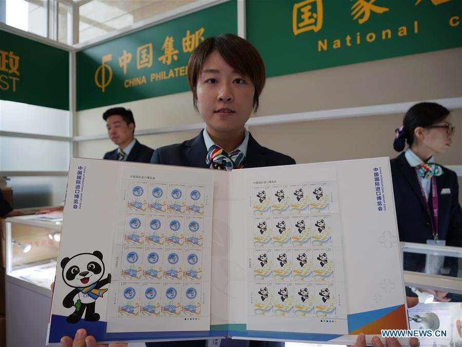 A staff member shows a set of stamps released to commemorate the China International Import Expo (CIIE) at the National Exhibition and Convention Center in Shanghai, east China, Nov. 5, 2018.(Xinhua/Wang Yiliang)