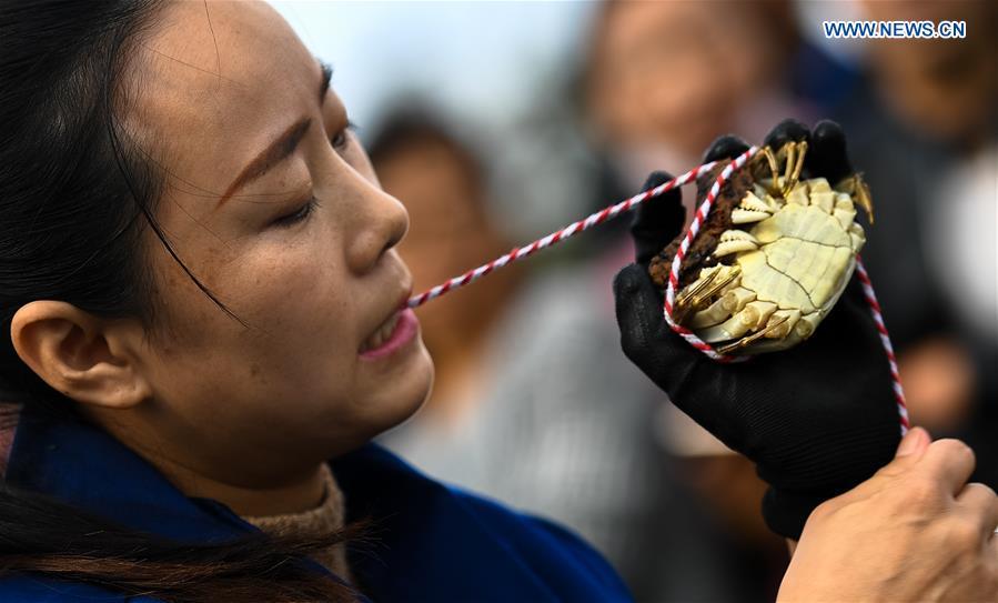 A woman takes part in a crab binding contest in Sihong County, east China\'s Jiangsu Province, Nov. 3, 2018. A total of 100 contestants participated in the event on Saturday. The winner bound 30 crabs within 3 minutes and 59 seconds. (Xinhua/Li Xiang)