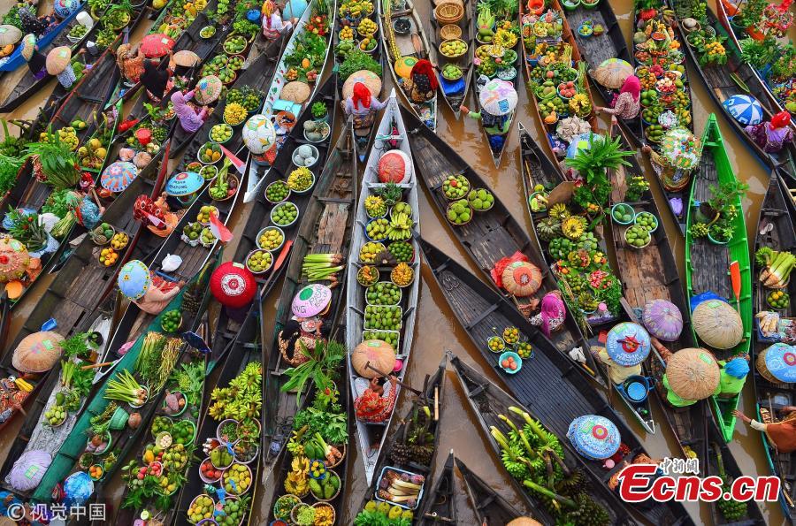 Hundreds of colorful boats tightly cram together at the Lok Baintan Floating Market to sell their hand-picked exotic fruit and vegetable in the Banjar district of Indonesia. The Lok Baintan floating market is in Southern Kalimantan Island dates back more than 500 years. Local people rely heavily on the waterways to make a living, with the markets now becoming tourist attractions.  (Photo/VCG)
