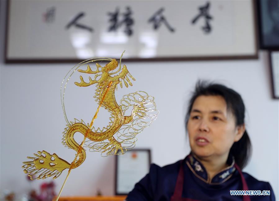 Folk artist Li Fengyan presents a sugar sculpture in Shenyang, northeast China\'s Liaoning Province, Nov. 6, 2018. The sugar sculpture of the Li family was listed as an intangible cultural heritage by the city of Shenyang. As the fifth-generation inheritor of her family\'s craft, Li Fengyan is making efforts to pass down the set of sugar-sculpting know-hows to her apprentices. (Xinhua/Yang Qing)
