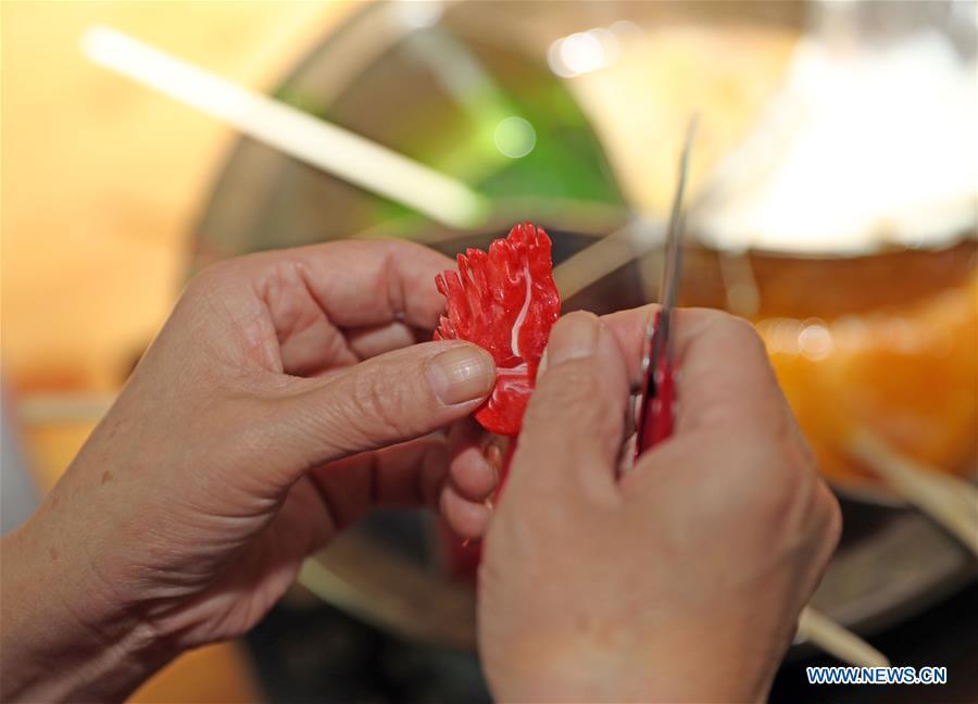 Folk artist Li Fengyan works on a sugar sculpture in Shenyang, northeast China\'s Liaoning Province, Nov. 6, 2018. The sugar sculpture of the Li family was listed as an intangible cultural heritage by the city of Shenyang. As the fifth-generation inheritor of her family\'s craft, Li Fengyan is making efforts to pass down the set of sugar-sculpting know-hows to her apprentices. (Xinhua/Yang Qing)