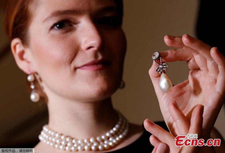 <?php echo strip_tags(addslashes(A model holds a natural pearl and diamond pendant once owned by Marie Antoinette together with wearing a pair of natural drops and a necklace featuring 119 natural pearls during a press preview ahead of the upcoming auction 