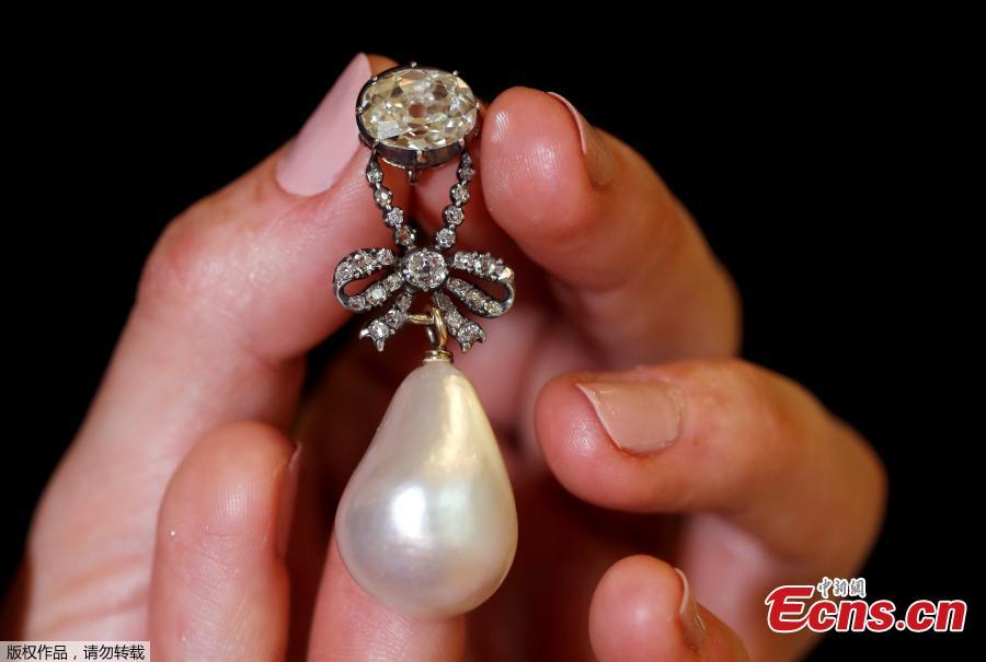 <?php echo strip_tags(addslashes(A natural pearl and diamond pendant once owned by Marie Antoinette is held by a model during a press preview ahead of the upcoming auction 