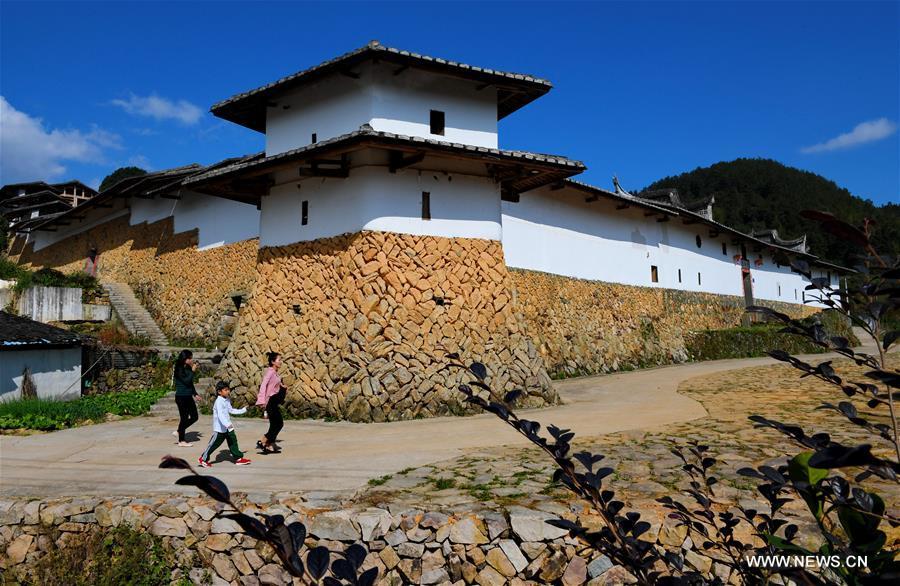 Tourists visit the Aijing Zhuang residential complex in Yangwei Village of Yongtai County, southeast China\'s Fujian Province, Nov. 11, 2018. The project, with a total of 361 rooms covering the area of over 5,200 square meters, was built during the reign of Emperor Daoguang in the Qing Dynasty. It has safeguarded the authentic character of the vernacular housing, defensive structures and waterways that are emblematic of this site, providing a model for other historic villages across China. The conservation of Aijing Zhuang residential complex demonstrates a sensitive approach to sustaining a rural settlement as a living place in harmony with its natural setting. Aijing Zhuang in November this year received the Award of Merit in the 2018 UNESCO Asia-Pacific Awards for Cultural Heritage Conservation. (Xinhua/Zhang Guojun)