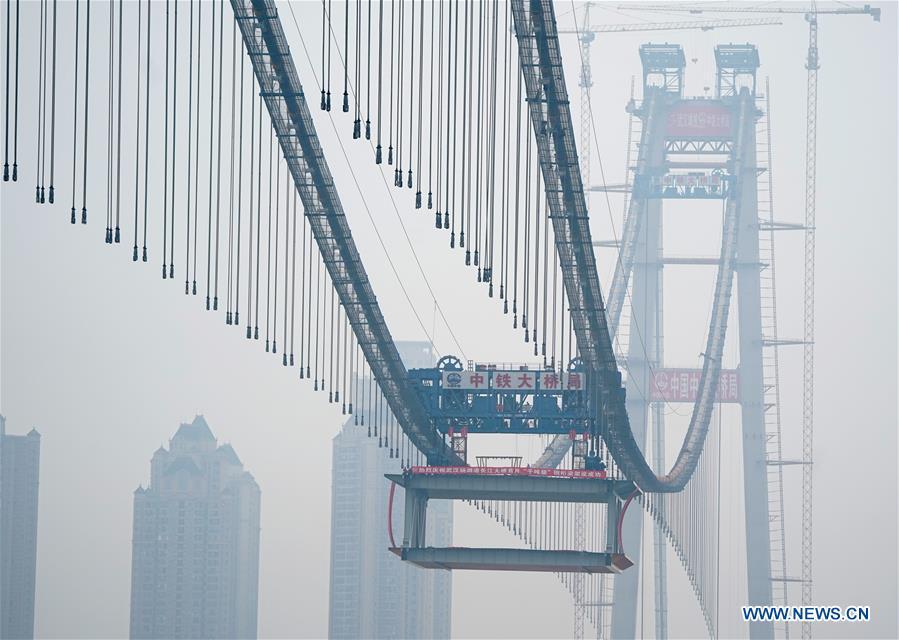 <?php echo strip_tags(addslashes(The installation of a 1,000-tonne steel beam is finished at the construction site of the Yangsigang Bridge across the Yangtze River in Wuhan, capital of central China's Hubei Province, on Nov. 15, 2018. Construction of a double-deck suspension bridge with the longest span in the world is expected to be completed in October 2019, said an engineer working on the project. The bridge, with a 1,700-meter-long main span across the Yangtze River in Wuhan, saw the first steal beam installed for the bridge deck Thursday. (Xinhua/Cheng Min))) ?>