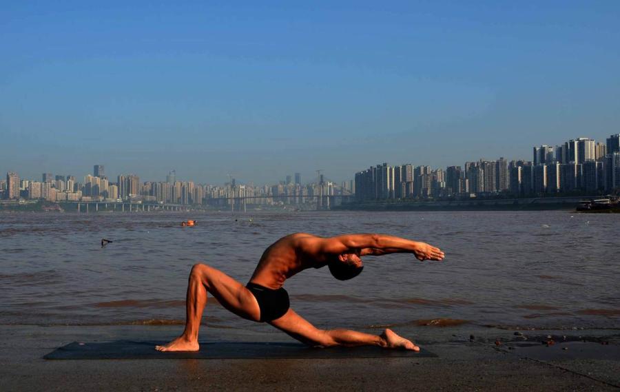 Wang Wanming, 61, a retiree in Southwest China\'s Chongqing municipality, has been practicing yoga almost every day by the Yangtze River for six years. His technique has made him a local celebrity. (Photo provided to chinadaily.com.cn)