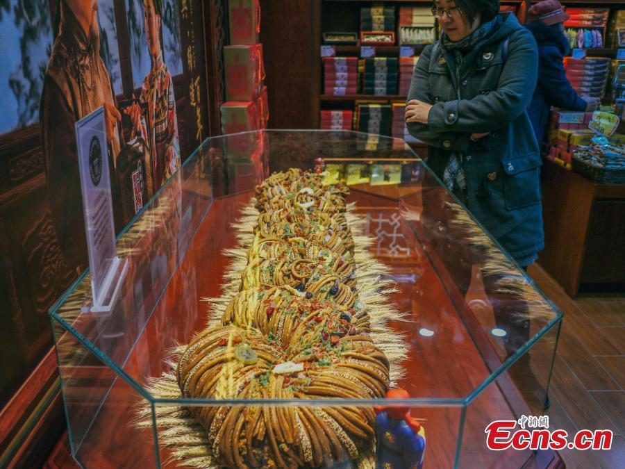 A 59-kilogram mahua, or fried dough twist is shown during a cultural festival in north China\'s city of Tianjin, November 18, 2018. Made of flour, sesame, walnut, peanuts and sweet-scented osmanthus, the snack usually comes deep fried. A variety of flavors are available regardless if you prefer to eat sweet or salty. (Photo: China News Service/ Tong Yu)