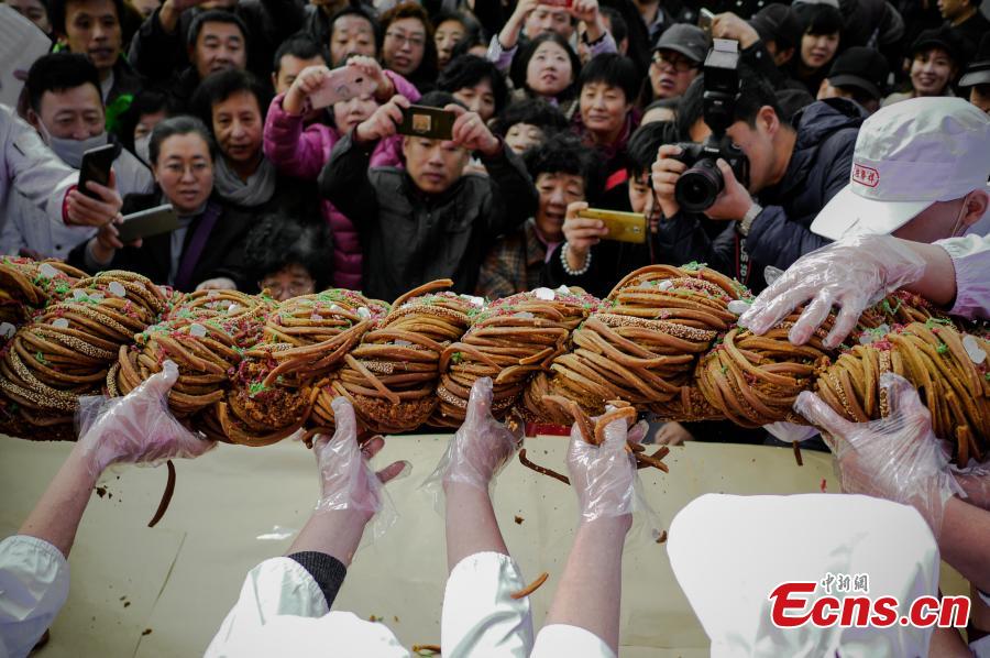A 59-kilogram mahua, or fried dough twist is shown during a cultural festival in north China\'s city of Tianjin, November 18, 2018. Made of flour, sesame, walnut, peanuts and sweet-scented osmanthus, the snack usually comes deep fried. A variety of flavors are available regardless if you prefer to eat sweet or salty. (Photo: China News Service/ Tong Yu)