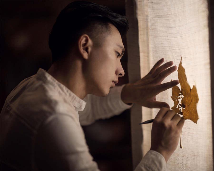 Artist Ding Li works on leaf art.  (Photo provided to chinadaily.com.cn)