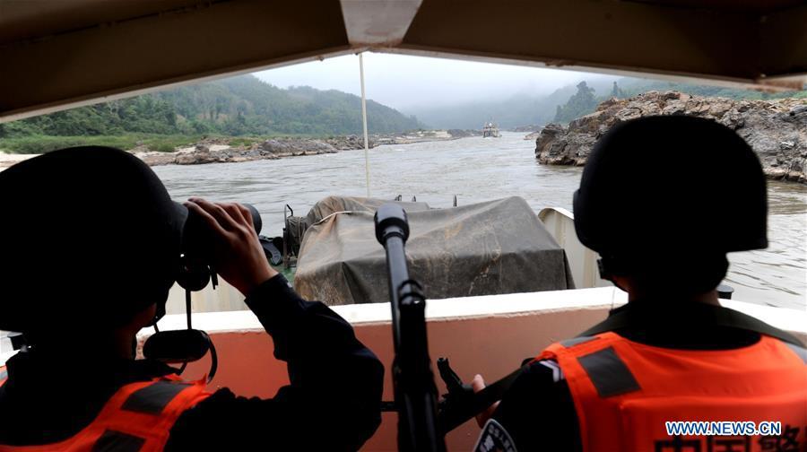 Chinese police officers guard on a vessel serving to escort commercial shipments along the Mekong River, Dec. 13, 2011. The 76th Mekong River joint patrol led by China, Laos, Myanmar, and Thailand started Nov. 20, 2018 from Guanlei Port, Xishuangbanna Dai Autonomous Prefecture in southwest China\'s Yunnan Province. According to Yunnan border police bureau, the joint patrol will last five days and cover a range of over 500 kilometers to enhance anti-terrorism capability, safeguard the security and crack down on cross-border crimes. Once every month since 2011, the patrols targeting drug trafficking, smuggling and other cross-border crimes along the Mekong, conduct random inspections in waters near key regions, including the Golden Triangle.The Mekong River, known as the Lancang River at the Chinese stretch, runs through China, Laos, Myanmar, Thailand, Cambodia and Vietnam. It is an important waterway for transnational shipping and a border area known for criminal activities. For seven years, security cooperation between the four countries has been getting closer with joint patrols a regular monthly phenomenon. The patrol includes anti-terrorism drills, police skill practices and anti-drug campaigns. Since December 2011, the joint patrols have covered more than 39,500 kilometers, with 122 merchant ships rescued and 582.28 kilograms of drugs seized. The cooperation has expanded to the cracking down on terrorism and human trafficking, as well as joint search and rescue. (Xinhua/Wang Xiaoxue)