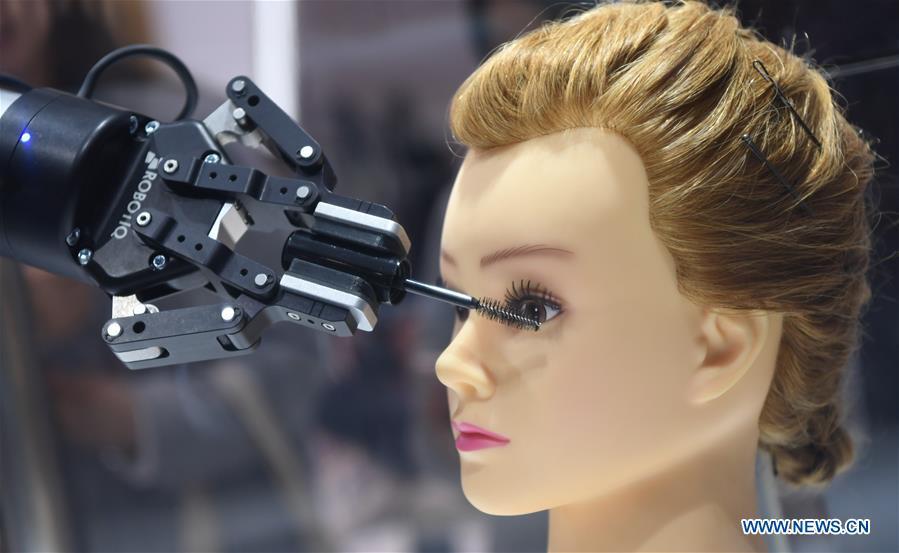 Photo taken on Nov. 9, 2018 shows a robotic makeup assistant performing at the Apparel, Accessories & Consumer Goods area of the first China International Import Expo (CIIE) in east China\'s Shanghai. From 1978 when China started its reform and opening-up policy, a door to the outside world has been opened. Along with the imported commodities, fashion ideas inevitably slipped into China and since then the country, which was somewhat lack of fashion diversity, started its journey to pursue fashions. Over the past four decades, the thirst for beauty has driven Chinese people to pursue every possible fashionable element. The change first came with dress when colorful and diversified clothing prevailed as against the former dominant blue and grey. For a time, men and women raced to hairdressers\' just for trendy hairdos. Eating McDonald\'s or western cuisine even once was regarded as a fashionable thing. However, the most conspicuous change is that Chinese people have become more inclusive and they tend to accept new fashions, styles and concepts. China nowadays is dazzling the world not only on the fashion stage but in many other fields. Changes in fashions, as a profile of society, has well interpreted the benefits to people brought by China\'s reform and opening-up policy. (Xinhua/Sadat)