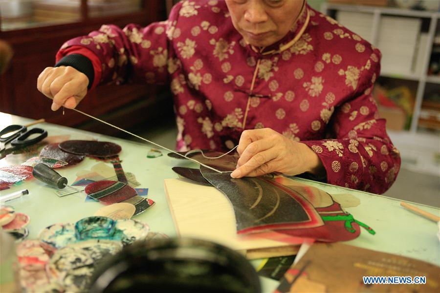 Zhang Kunrong sews parts together to make a shadow puppetry piece in Haining City, east China\'s Zhejiang Province, Nov. 20, 2018. Zhang Kunrong, 79, a locally born shadow puppetry player, is an inheritor of the Haining shadow puppetry, a form of traditional theatre acted by colorful silhouette figures made from leather or paper, accompanied by music and singing. A typical variety popular in south China, Haining shadow puppetry, a national intangible cultural heritage, has a history of about 900 years dating back to the Southern Song Dynasty (AD 1127-1279). Obsessed with the shadow play since childhood, Zhang Kunrong was recruited to the provincial shadow puppetry troupe in 1958 and soon became a mainstay after two year\'s practice and in the later years staged performances at home and abroad as Haining shadow puppetry grows popular. Nowadays, Zhang works more on script writing, directing and teaching apprentices. Haining shadow puppetry was listed as one of the state-level intangible cultural heritages in 2006 and was included in the UNESCO Intangible Cultural Heritage of Humanity list in 2011. (Xinhua/Zhu Weixi)