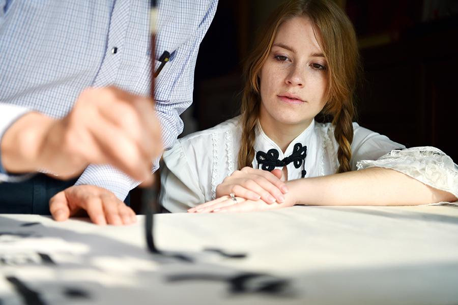 Francis learns calligraphy from her father-in-law.  (Photo/Xinhua)