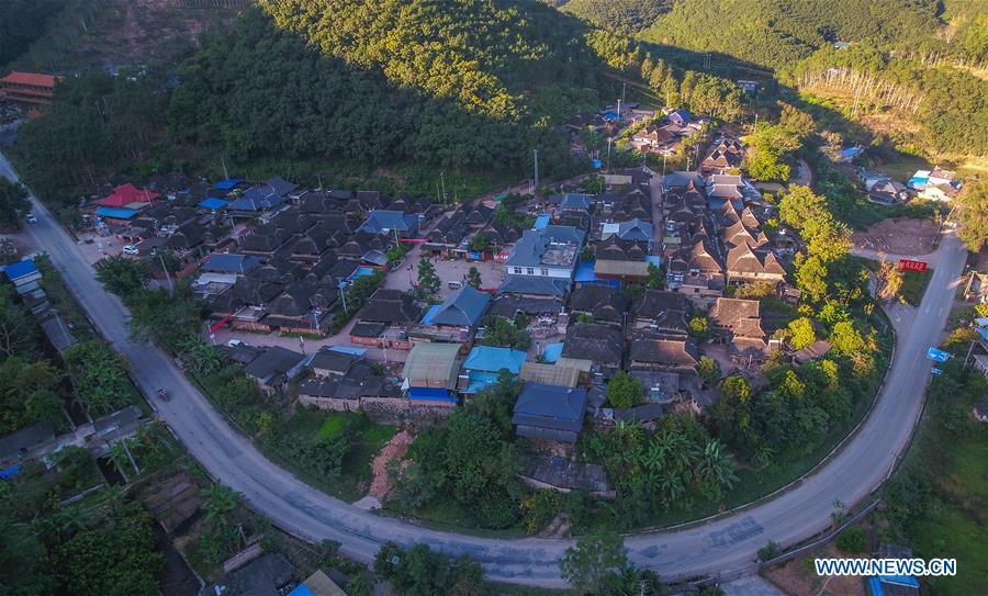 <?php echo strip_tags(addslashes(Aerial photo taken on Nov. 20, 2018 shows a corner of Bapiao Village in Jino Ethnic Township on Jino Mountain in Jinghong of Xishuangbanna Dai Autonomous Prefecture, southwest China's Yunnan Province. With a population of slightly over 20,000, the Jino people had only been officially acknowledged in 1979 as an independent ethnic group of China. Until 1949, most of them had lived for generations in primitive mountain tribes in southwest China's Yunnan Province. Over the four decades since it embraced the reform and opening-up policy, China has spared no effort to support ethnic groups with smaller populations. Life on Jino Mountain, where most Jino communities are located, saw positive changes in parallel with improvements in local politics, economy, technology, education, culture, health care, ecology, ethnic development and other social undertakings. Just like its 55 ethnic brethren, the Jino people also benefit from China's reform and opening-up in seeking a prosperous life. In Jino Ethnic Township on the Jino Mountain, residents now have direct access to road, water, electricity, TV and radio, as well as the mobile network. Ninety percent of the residents have moved into new houses. Most residents own motorcycles and tractors, and some of them have purchased cars. More people have increased their income by selling local specialty products via the internet, whereas in the past, doing business was perceived as a shame. Currently, the primary education in Jino Ethnic Township achieved 100 percent coverage for all school-age children. More than 99 percent of residents have joined the rural cooperative medical insurance programme. The Jino ethnic culture undergoes protection and inheritance: the great drum dance of the Jino people has been listed as one of China's national intangible cultural heritages. (Xinhua/Yang Muyuan))) ?>