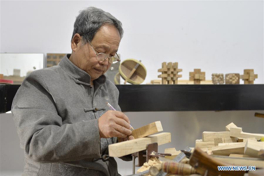 Hou Quanchen designs a Kong Ming Lock in Shahe City, north China\'s Hebei Province on Nov. 28, 2018. Hou Quanchen, who is in his seventies, has devoted himself in the studying and making of Kong Ming Locks and has tried to promote this art among local residents ever since his retirement. (Xinhua/Tian Xiaoli)