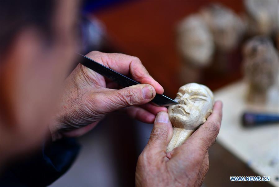 Xu Zhuchu, a national-level intangible cultural heritage inheritor of Zhangzhou wood puppet head carving, carves a puppet head at a studio in Zhangzhou City, southeast China\'s Fujian Province, Nov. 28, 2018. Listed as one of the national intangible cultural heritages in 2006, Zhangzhou wood puppet carving features exquisite craftsmanship. Xu\'s works of puppet head carving are known for rich and delicate facial expressions. Nowadays, Xu and his son, Xu Qiang, set up a studio of wood puppet to popularize local puppet culture. (Xinhua/Wei Peiquan)