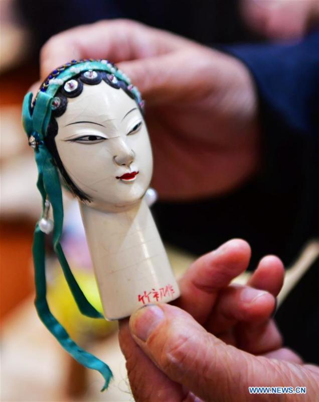<?php echo strip_tags(addslashes(Xu Zhuchu, a national-level intangible cultural heritage inheritor of Zhangzhou wood puppet head carving, displays a wood puppet head at a studio in Zhangzhou City, southeast China's Fujian Province, Nov. 28, 2018. Listed as one of the national intangible cultural heritages in 2006, Zhangzhou wood puppet carving features exquisite craftsmanship. Xu's works of puppet head carving are known for rich and delicate facial expressions. Nowadays, Xu and his son, Xu Qiang, set up a studio of wood puppet to popularize local puppet culture. (Xinhua/Wei Peiquan))) ?>