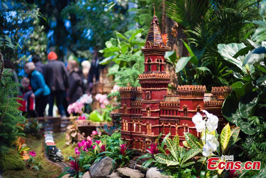 Visitors are attracted by model trains navigating painstakingly crafted miniatures of New York City’s built environment, all made entirely out of plant parts at Holiday Train Show in New York on December 1, 2018. At the show, model trains zip through a display of more than 175 New York landmarks, each re-created with bark, leaves, and other natural materials. (Photo: China News Service/Liao Pan)