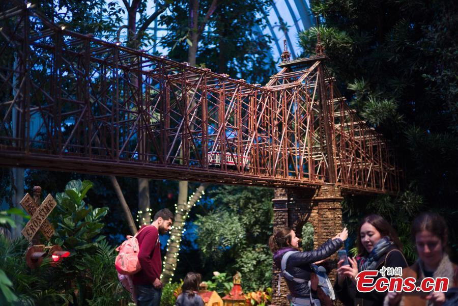 Visitors are attracted by model trains navigating painstakingly crafted miniatures of New York City’s built environment, all made entirely out of plant parts at Holiday Train Show in New York on December 1, 2018. At the show, model trains zip through a display of more than 175 New York landmarks, each re-created with bark, leaves, and other natural materials. (Photo: China News Service/Liao Pan)