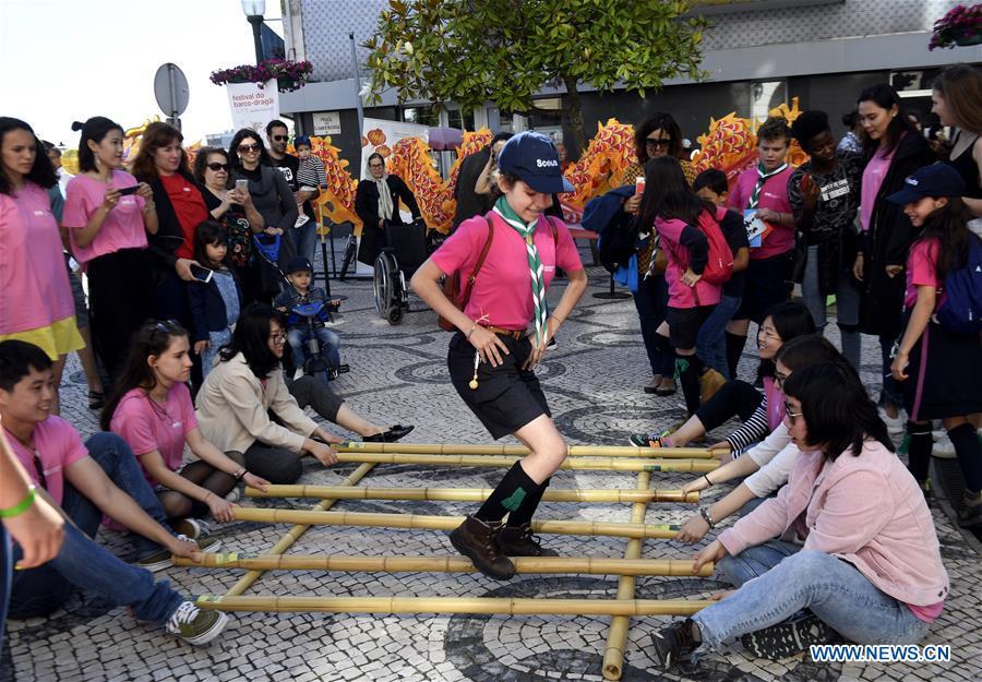<?php echo strip_tags(addslashes(Photo taken on June 16, 2018 shows students from the Confucius Institute of the Aveiro University performing bamboo pole dance in an activity of the Dragon Boat Festival in Aveiro, Portugal. (Xinhua/Zhang Liyun))) ?>