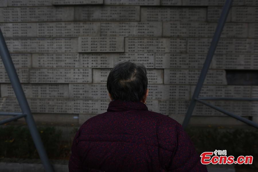 Survivor of the Nanjing Massacre Shi Xiuying, 92, pays tribute to the victims of the Nanjing Massacre before the memorial hall wall where the victims\' names are engraved during commemoration activities in Nanjing, capital of east China\'s Jiangsu Province, Dec. 3, 2018. The Nanjing Massacre took place when Japanese troops captured the city on Dec. 13, 1937. Over six weeks, they killed 300,000 Chinese civilians and unarmed soldiers. In February 2014, China\'s top legislature designated December 13 as the national memorial day for victims of the Nanjing Massacre. Starting Monday, family members of the victims began a series of commemoration activities such as laying flowers, burning incense and reading letters in front of the Memorial Hall of the Victims in Nanjing Massacre by Japanese Invaders.