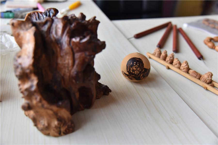 Artworks made of olive pits, carved by Zhu.  (Photo by Qian Lei for chinadaily.com.cn)