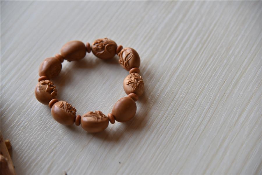 A bracelet made of olive pits, carved by Zhu. (Photo by Qian Lei for chinadaily.com.cn)