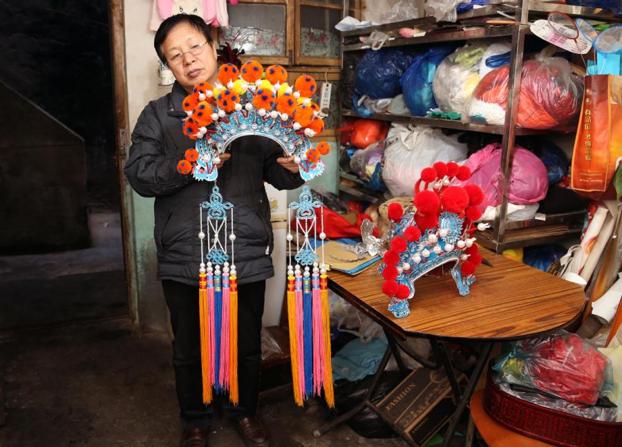 Han Xiaoli presents a headdress he made. (Photo by Huo Yan/chinadaily.com.cn)