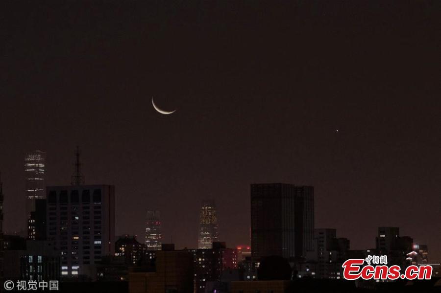 The moon hangs out nest to Venus in the sky of Beijing on Tuesday night, December 4, 2019. The crescent moon was just 3.6 degrees from Venus by twilight, appearing right next to each other to the naked eye.  (Photo/IC)