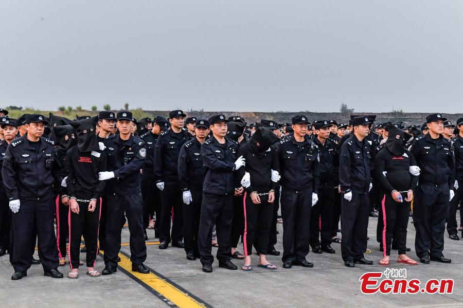 A total of 233 telecom fraudsters were returned from Cambodia to southern China\'s Guangzhou on December 6, 2018. The suspects are behind more than 2,000 fraud cases across over 20 provincial regions, involving over 63 million yuan (about 9.14 million U.S. dollars), according to the police. The police said the suspects changed their phone numbers and pretended to be public security, procuratorate or court officers to threaten the victims for money. (Photo: China News Service/Chen Jimin)