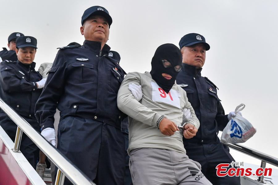 A total of 233 telecom fraudsters were returned from Cambodia to southern China\'s Guangzhou on December 6, 2018. The suspects are behind more than 2,000 fraud cases across over 20 provincial regions, involving over 63 million yuan (about 9.14 million U.S. dollars), according to the police. The police said the suspects changed their phone numbers and pretended to be public security, procuratorate or court officers to threaten the victims for money. (Photo: China News Service/Chen Jimin)