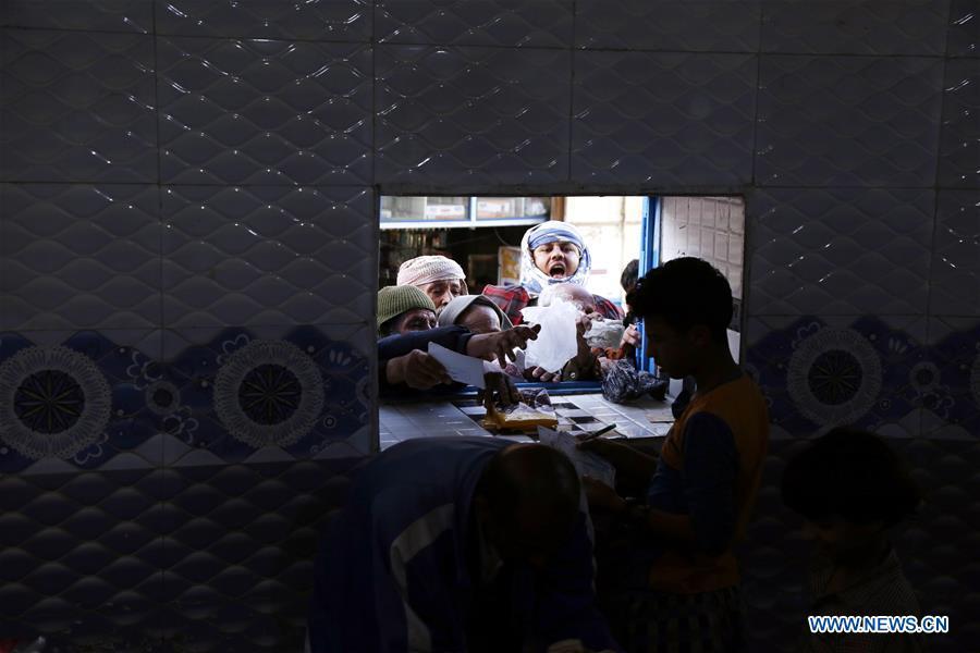 Yemeni people gather in front of a window of a charity center to receive food aid in Sanaa, Yemen, on Dec. 9, 2018. An estimated 85,000 children under the age of five may have died from extreme hunger between April 2015 and October 2018, according to the latest data released by Save the Children, an international organization for children\'s rights. (Xinhua/Mohammed Mohammed)