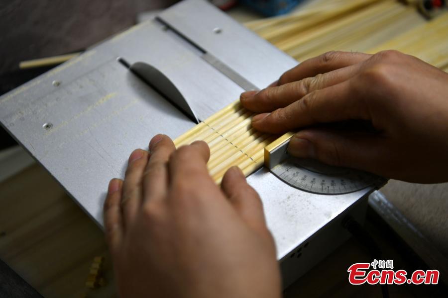 Xu Ruibin works with bamboo skewers for a creation at his wonton restaurant in Shijiazhuang City, Hebei Province, Dec. 10, 2018. Xu said he taught himself the handicraft in three months and is now able to make various designs. In the past two years, he has created over 300 works, including landmark buildings and elaborate villa miniatures. (Photo: China News Service/Zhai Yujia)