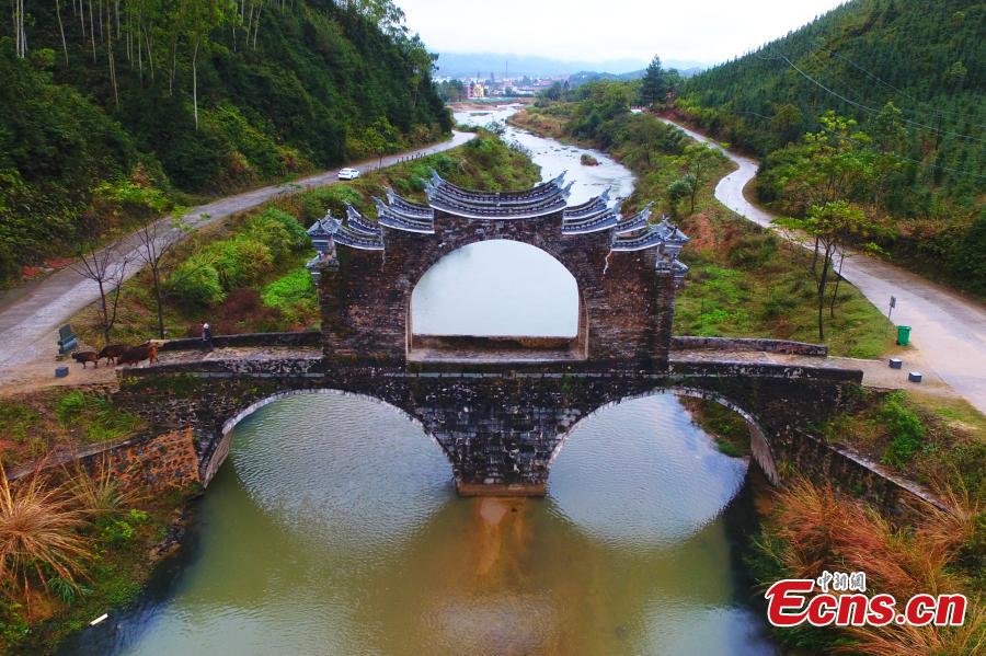 <?php echo strip_tags(addslashes(An aerial view of Taiping Bridge (Peace Bridge) in Longnan County, Jiangxi Province, Dec. 9, 2018. The double-layered stone bridge has two archways at the bottom and one on the top, a rare design. Built during the Ming Dynasty (1368-1644), the 50-meter-long bridge is now a cultural relic under national protection. (Photo: China News Service/Liu Zhankun))) ?>