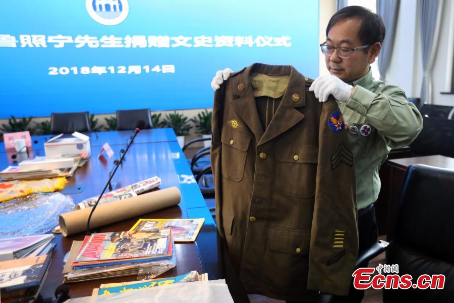 <?php echo strip_tags(addslashes(Chinese-American Lu Zhaoning donates historical materials to the Memorial Hall of the Aviator Martyrs in the War of Resistance against Japanese Aggression in Nanjing City, Jiangsu Province, Dec. 14, 2018. The relics included pilot’s suits, books by Flying Tiger pilots and other materials about WWII war planes. Lu’s relative Lu Meiyin served as a flight attendant in the war. The memorial hall shows the names and a basic introduction in Chinese, English and Russian on thousands of pilots from China, the United States and Soviet Union who died in China during the war. (Photo: China News Service/Yang Bo))) ?>