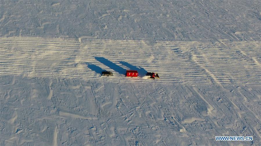 A snowmobile transports supplies to the Zhongshan Station in Antarctica, Dec. 4, 2018. China\'s 35th Antarctic research expedition team finished the first phase of unloading supplies operation on Friday. A total of 1,605 tons of supplies have been transported from China\'s research icebreaker Xuelong to the destination. (Xinhua/Liu Shiping)