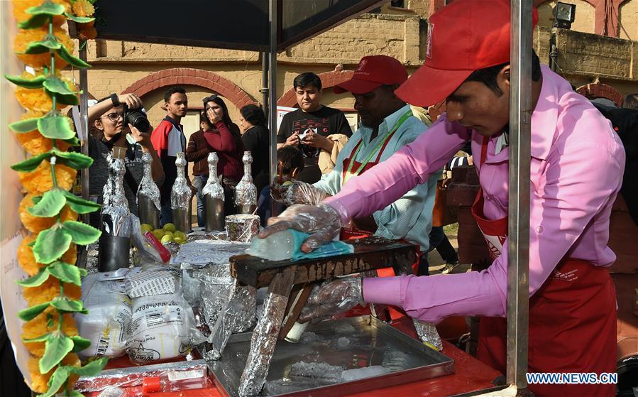 Food vendors make cold drinks on a street food festival held in New Delhi, India, on Dec. 16, 2018. (Xinhua/Zhang Naijie)