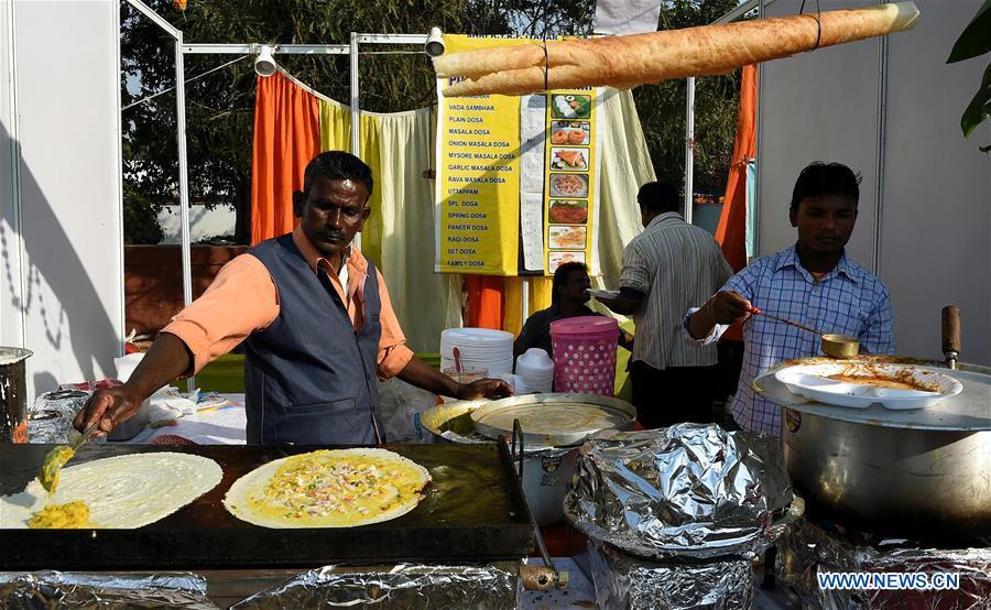 Food vendors cook dishes on a street food festival held in New Delhi, India, on Dec. 16, 2018. (Xinhua/Zhang Naijie)