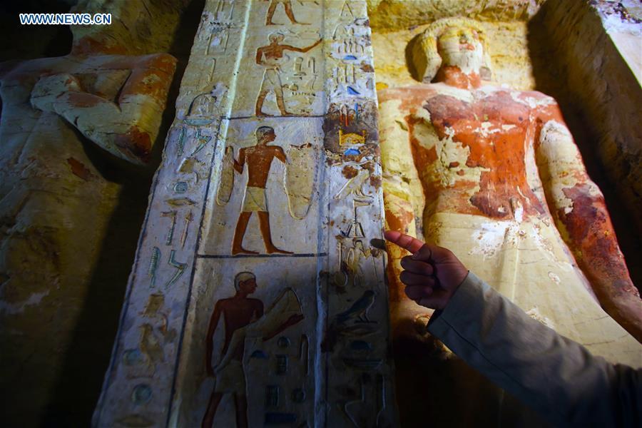 A man points at paintings in a tomb in Saqqara Necropolis in Giza, Egypt, Dec. 15, 2018. Egyptian Antiquities Minister Khaled al-Anany announced Saturday the discovery of an \