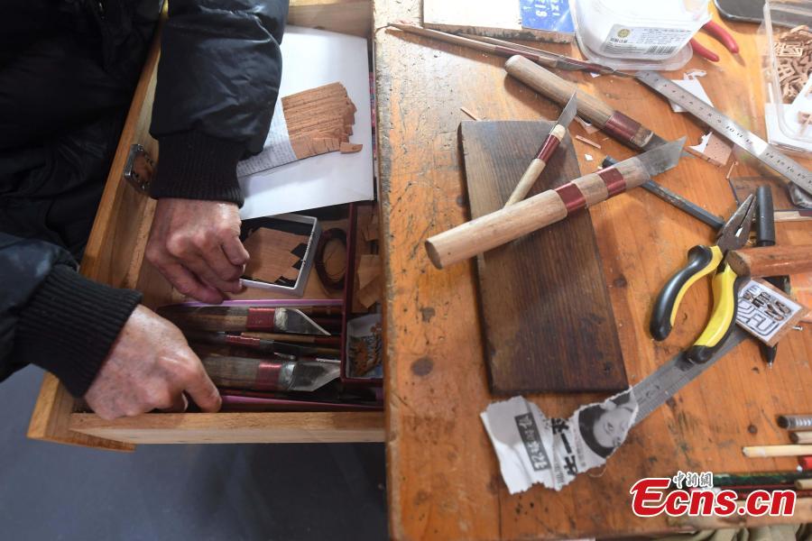 A craftsman carves on bark at a workshop in Fuzhou City, East China\'s Fujian Province. As an intangible cultural heritage, bark carving is regarded as one of the three treasures of Fujian. Craftsmen can carve elaborate scenes, including pavilions, bridges and landscape features, onto the bark. The craft is in decline today as fewer young people are interested in the time-consuming profession. (Photo: China News Service/Zhang Bin)