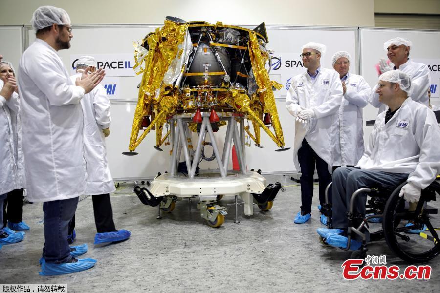 Members of Israeli non-profit group SpaceIL and representatives from Israel Aerospace Industries (IAI) hold a time capsule next to an unmanned spacecraft during a presentation to the media of the time capsule, intended to travel to the moon with the spacecraft in early 2019, at the clean room of IAI\'s space division in Yehud, Israel Dec. 17, 2018. (Photo/Agencies)
