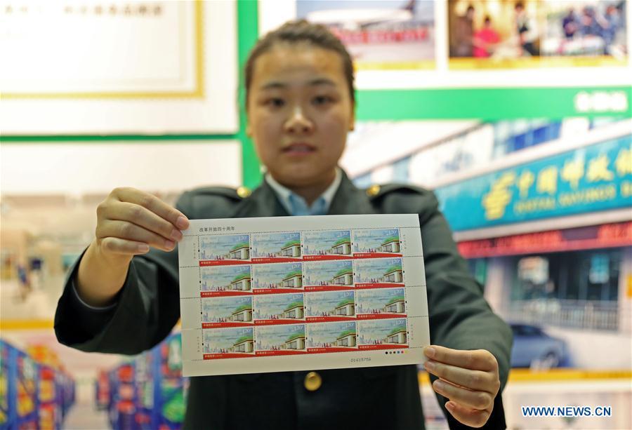 A staff member shows the commemorative stamps marking the 40th anniversary of China\'s reform and opening up at the post office of Liaoning provincial archives in Shenyang, capital of northeast China\'s Liaoning Province, Dec. 18, 2018. China Post released a set of commemorative stamps and one souvenir sheet marking the 40th anniversary of China\'s reform and opening up on Tuesday. (Xinhua/Yang Qing)
