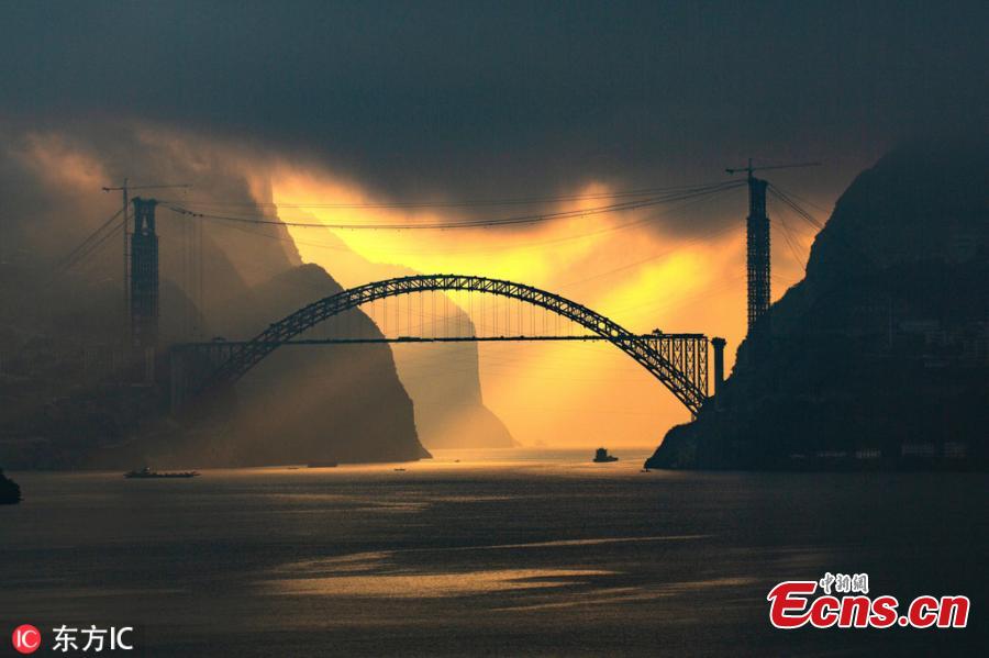 Sunrise at the construction site of a bridge over the Yangtze River in Zigui County, Central China\'s Hubei Province. The confluence of Xiangxi Stream, a tributary of China\'s greatest river, and Xiling Gorge, one of the Three Gorges, is a tourist attraction renowned for its magnificent scenic beauty. (Photo/IC)