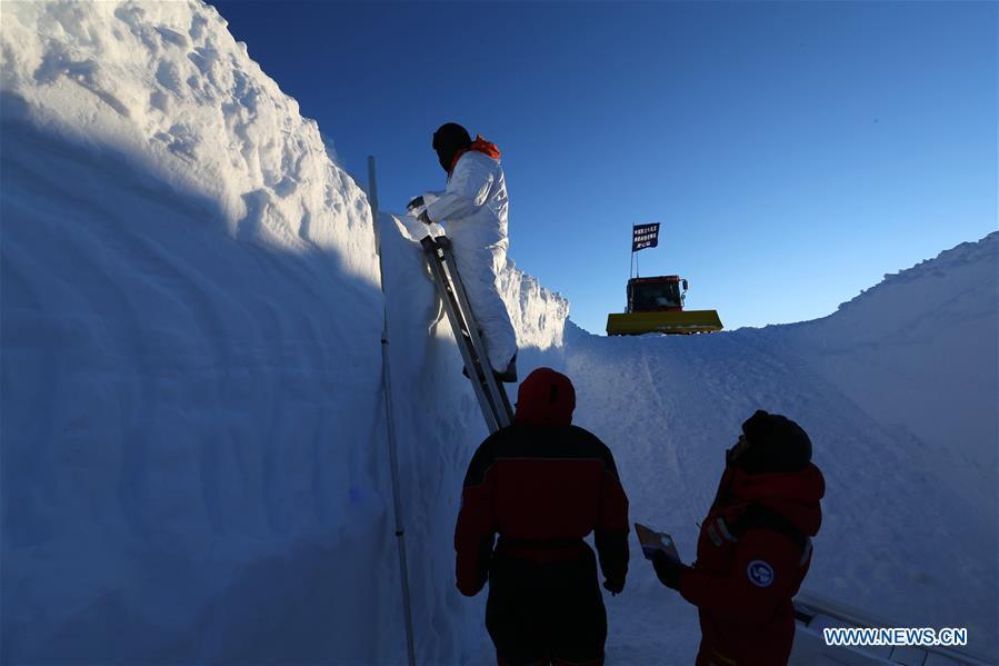 A member of China\'s 35th research expedition takes the sample from a snow pit in Antarctica, Dec. 20, 2018. (Xinhua/Liu Shiping)