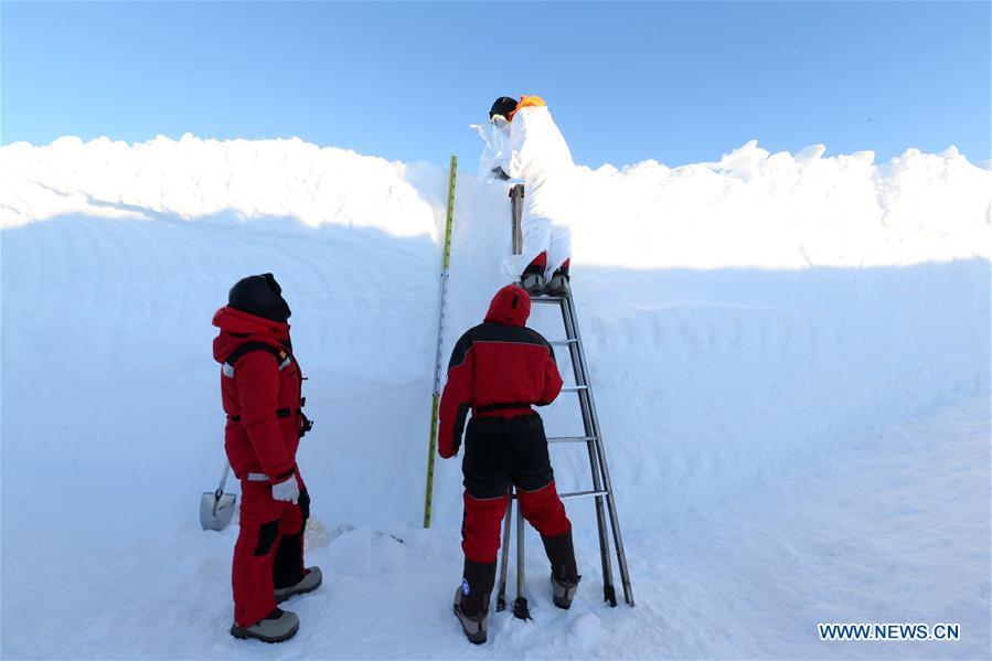 A member of China\'s 35th research expedition takes the sample from a snow pit in Antarctica, Dec. 20, 2018. (Xinhua/Liu Shiping)