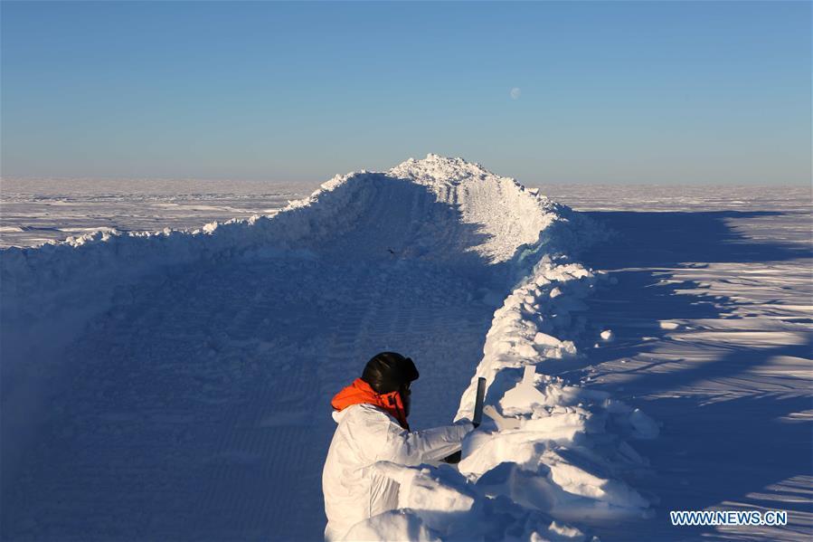 A member of China\'s 35th research expedition takes the sample from a snow pit in Antarctica, Dec. 20, 2018. (Xinhua/Liu Shiping)