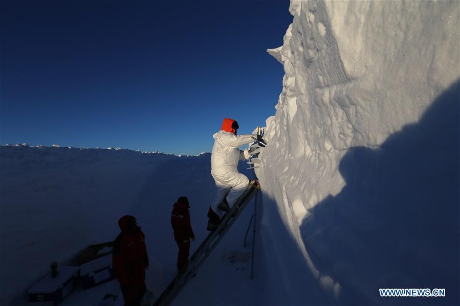 A member of China\'s 35th research expedition takes the sample from a snow pit in Antarctica, Dec. 20, 2018. (Xinhua/Liu Shiping)