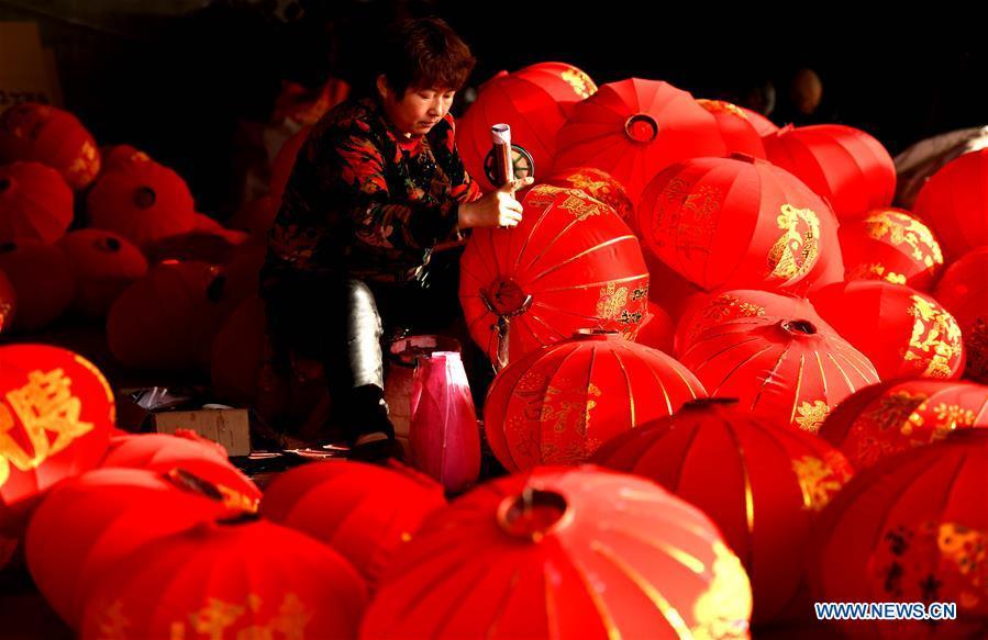 A worker makes red lanterns in Tuntou Village, Gaocheng District, Shijiazhuang City, north China\'s Hebei Province, Dec. 23, 2018. As the New Year approaches, lantern craftsmen in Gaocheng, which is known for its lantern manufacturing, are busy making red lanterns. (Xinhua/Chen Qibao)